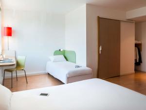 a room with a bed and a chair and a desk at Ibis Budget Lyon Centre - Gare Part Dieu in Lyon