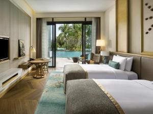 une chambre d'hôtel avec deux lits et une télévision dans l'établissement Sofitel Sanya Leeman Resort, à Sanya