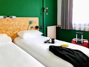 エヴルーにあるGreet Hotel Evreux Centre - Route de Normandie by Accorの緑の壁の部屋にベッドが2つある