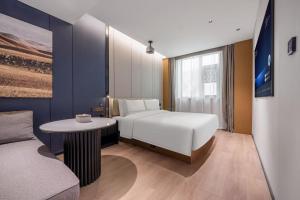 a bedroom with a bed and a table and a couch at Atour Hotel Beijing Nanluoguxiang Beixinqiao Subway Station in Beijing +43 photos