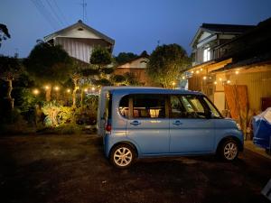 a small blue car parked in a yard at night at 美禄の杜 古民家離れ 別途焚火やピザ窯体験の可能な農家民泊 in Ichihara +1 photo
