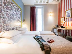 Postel nebo postele na pokoji v ubytování Mercure Paris Notre Dame Saint Germain des Prés