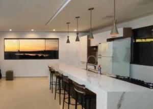 eine Küche mit einer Theke mit Barhockern in der Unterkunft Casa de Campo Tio Mário in Guaíra