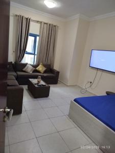 a living room with a couch and a flat screen tv at Super stylish in Ajman 