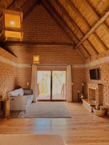 a large living room with a large window in a brick wall at Maria Rita dos Canyons in Praia Grande