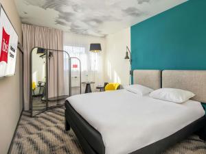 a bedroom with a large white bed and a blue wall at ibis Warszawa Centrum in Warsaw +47 photos