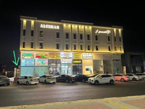 a building with cars parked in a parking lot at night at Modern apartment with elegant design in Dhahran