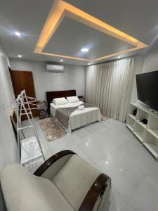 Villa chapman II في بوزيوس: غرفة نوم بها سرير وتلفزيون وأريكة