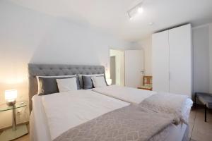 a bedroom with a large bed with white sheets and pillows at Ferienwohnung Talblick in Kalkofen
