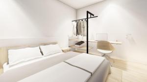 a white bedroom with a bed and a chair at OakstoneLodge- Gite avec Jacuzzi Piscine et Sauna in Houyet