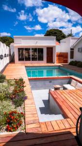 una piscina con terraza de madera y una casa en Infinity Homes Apartment Dodoma, en Dodoma
