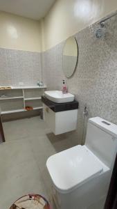 une salle de bain avec toilettes, lavabo et miroir dans l'établissement Crane Island Seafront Villa, 