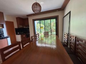 une salle à manger avec une grande table en bois et une grande fenêtre dans l'établissement Crane Island Seafront Villa, 