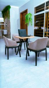 una mesa y sillas con un ordenador portátil encima en Infinity Homes Apartment Dodoma, en Dodoma