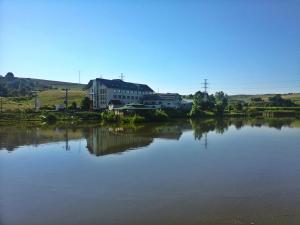 a large house sitting next to a large body of water at Hotel Dumbrava in Rupea