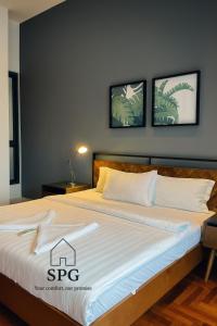 a bedroom with a large bed with two pictures on the wall at Suites Apartment At The Mews KLCC in Kuala Lumpur