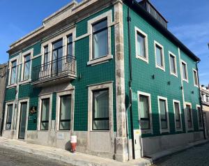 a green building with a fire hydrant in front of it at Oporto Station Hostel & Rooms in Porto