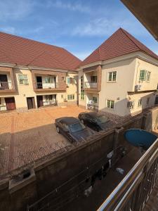 two cars parked in a parking lot in front of a building at Exotic Modern 2BR Apartment in Independence Layout in Enugu