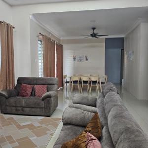 a living room with a couch and a table at Residensi Lourve Homestay Sungai Petani in Sungai Petani