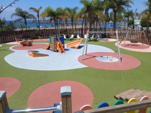 ein Spielplatz mit Rutschen und Spielgeräten in einem Park in der Unterkunft Holiday Esquinita in Juan Grande