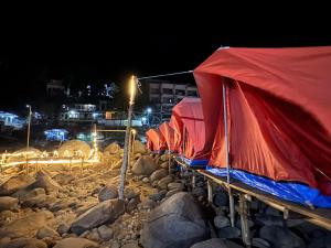 a row of tents on the rocks at night at Front view campsite in Shillong