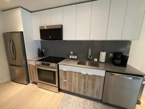 a kitchen with white cabinets and stainless steel appliances at Bright warm & spacious 1 BR in North End Halifax in Halifax