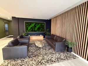 a living room with two leather couches and a tv at Bright warm & spacious 1 BR in North End Halifax in Halifax