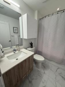 a bathroom with a sink and a toilet and a shower at Bright warm & spacious 1 BR in North End Halifax in Halifax +11 photos