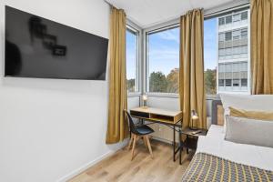 a bedroom with a bed and a desk and a window at Urban Havn - 6 Apartments mit top Anbindung für bis zu 34 Personen in Dreieich