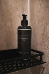 una botella negra de jabón sobre un estante en Centrum Hotel, en Akureyri 59 fotos más