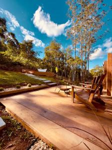 a wooden deck with benches and a picnic table at Maria Rita dos Canyons in Praia Grande