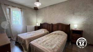 Un dormitorio con dos camas y una mesa y una ventana. en Chateau st-auriol - le caviste, en Saint-Pierre-des-Champs