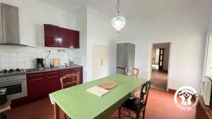 a kitchen with a table and a green table and chairs at Chateau st-auriol - le caviste in Saint-Pierre-des-Champs +13 photos