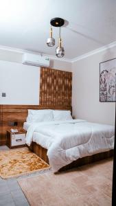 Un dormitorio con una cama grande con cabecero de madera. en Infinity Homes Apartment Dodoma, en Dodoma