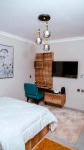 Un dormitorio con una cama, un escritorio y un televisor. en Infinity Homes Apartment Dodoma, en Dodoma 24 fotos más