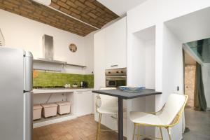 a kitchen with a table and two white chairs at DrsRome - Colosseum Loft in Rome