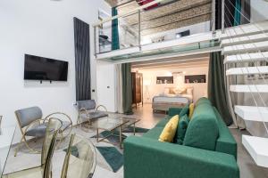 a living room with a green couch and a bed at DrsRome - Colosseum Loft in Rome