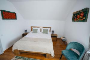 a bedroom with a white bed and two chairs at Prispa Casei in Floreşti