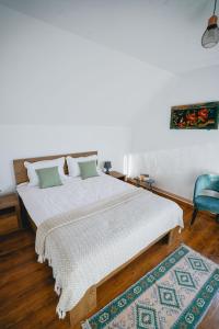 a bedroom with a large bed and a blue chair at Prispa Casei in Floreşti