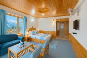 Hotel The Sita Classic - Best Selling Property of Manali 2024-25 في مانالي: غرفة بسرير واريكة وطاولة