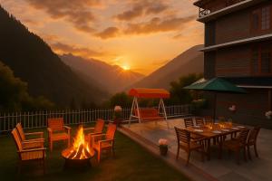 Hotel The Sita Classic - Best Selling Property of Manali 2024-25 في مانالي: فناء مع حفرة نار وطاولة وكراسي