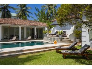 a backyard with a swimming pool and a house at Wijaya Giri walkable to beach pool chef in Ahangama