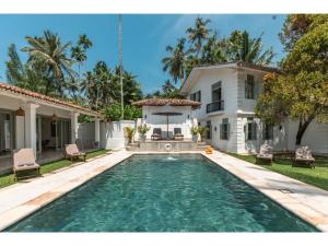 a swimming pool in front of a house at Wijaya Giri walkable to beach pool chef in Ahangama