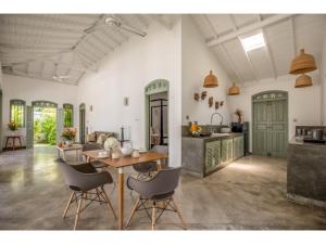 a kitchen and a living room with a table and chairs at Wijaya Giri walkable to beach pool chef in Ahangama