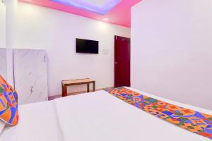 a bedroom with a bed and a tv on the wall at FabHotel Devi Residency Wakad in Pune +17 photos