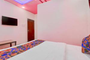 a bedroom with a bed and a tv on the wall at FabHotel Devi Residency Wakad in Pune