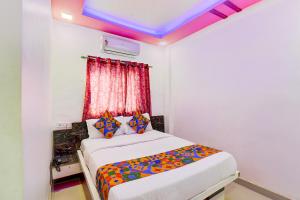 a bedroom with a bed in a room with a ceiling at FabHotel Devi Residency Wakad in Pune