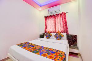 a bedroom with a bed with a colorful comforter at FabHotel Devi Residency Wakad in Pune