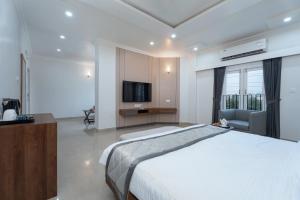 a bedroom with a large bed and a television at Himalayan Gateway By Dept Of Tourism, GTA in Jāmb