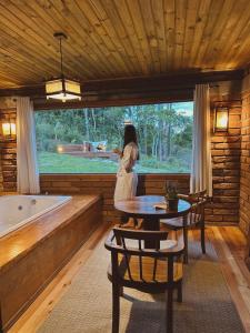 a woman standing in a room next to a tub at Maria Rita dos Canyons in Praia Grande
